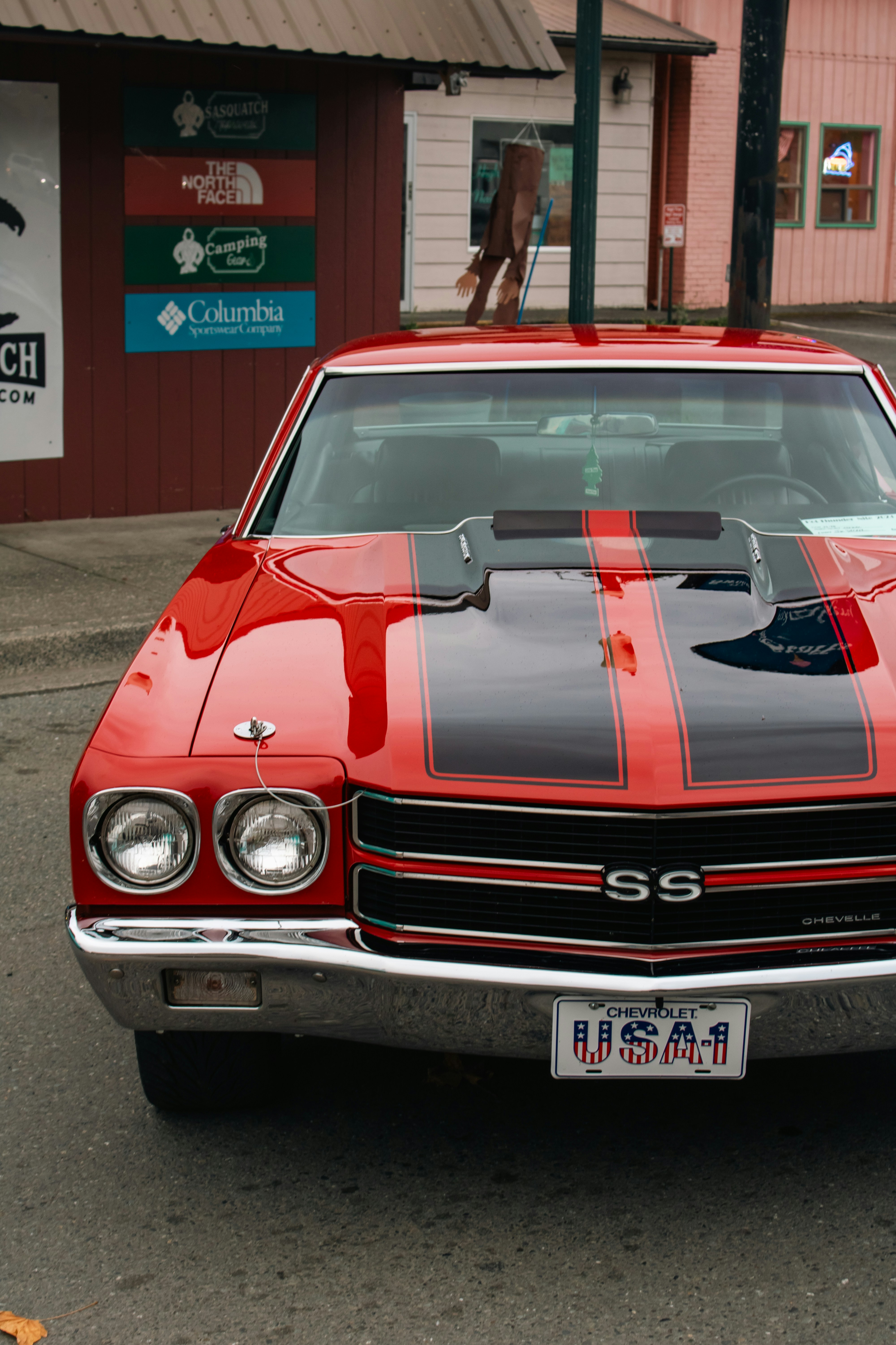 A red and black car parked in front of a building