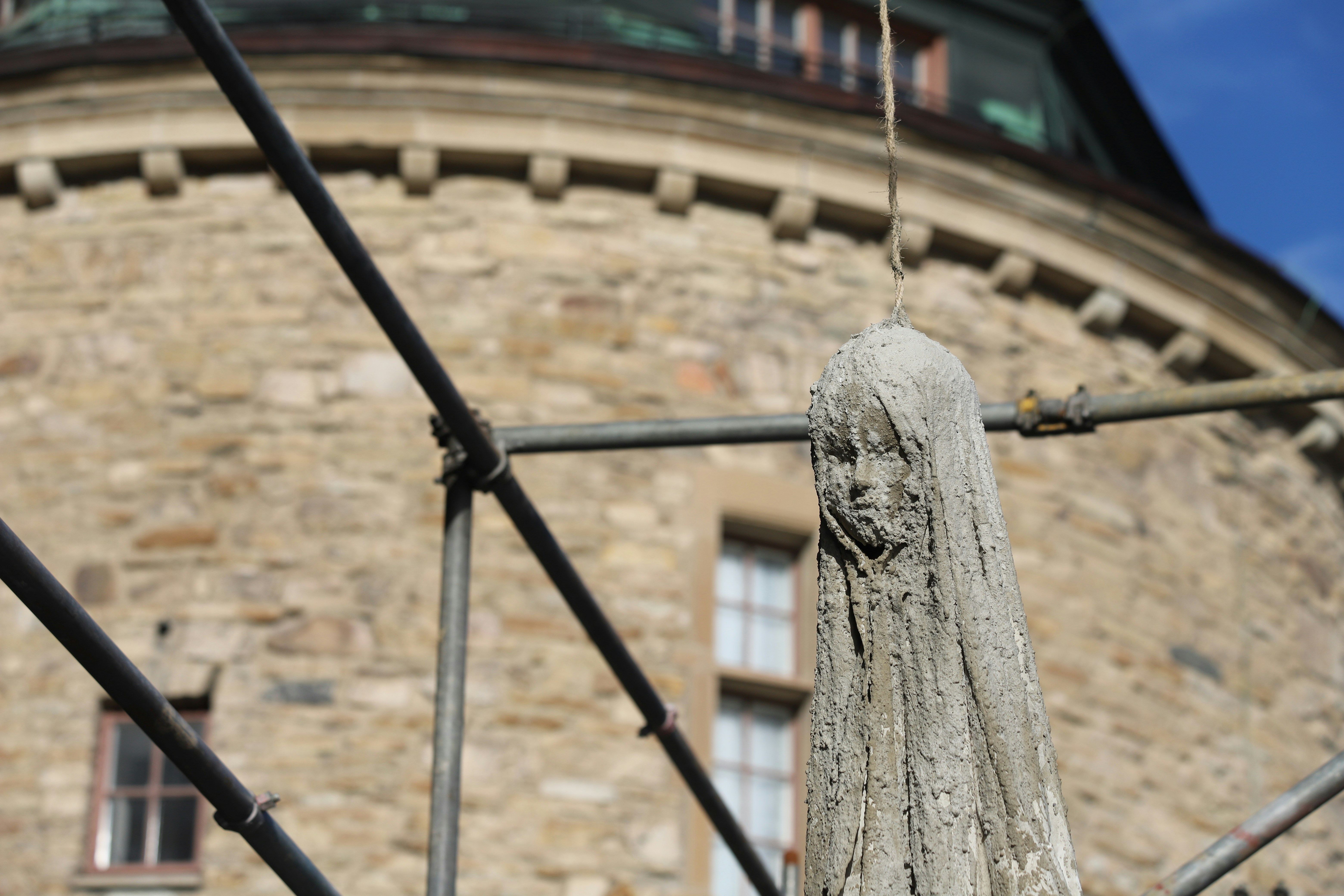 A stone building with a clock tower in the background
