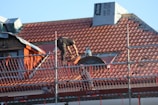 A man on a roof working on a new home's roof