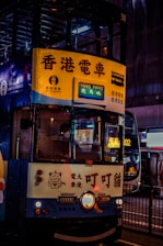 A double decker bus driving down a street at night