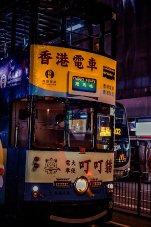 A double decker bus driving down a street at night