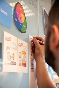 A man writing on a wall with a marker