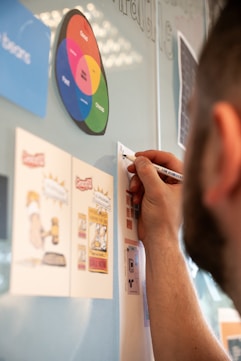 A man writing on a wall with a marker
