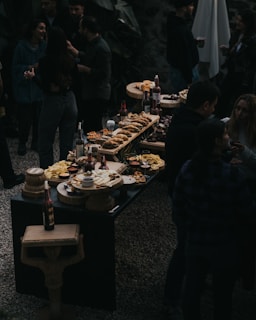 A group of people standing around a table filled with food