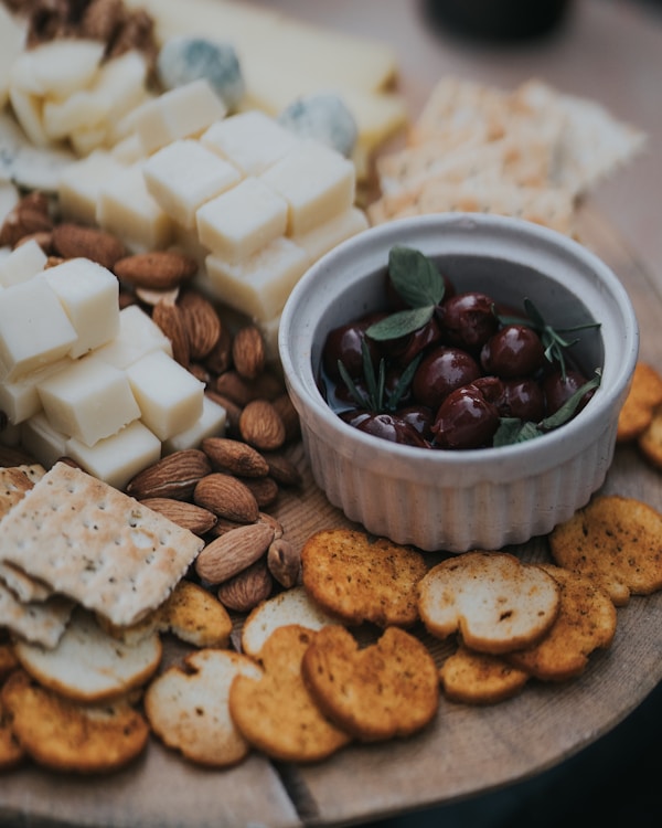 A platter of cheese, crackers, nuts, and olives