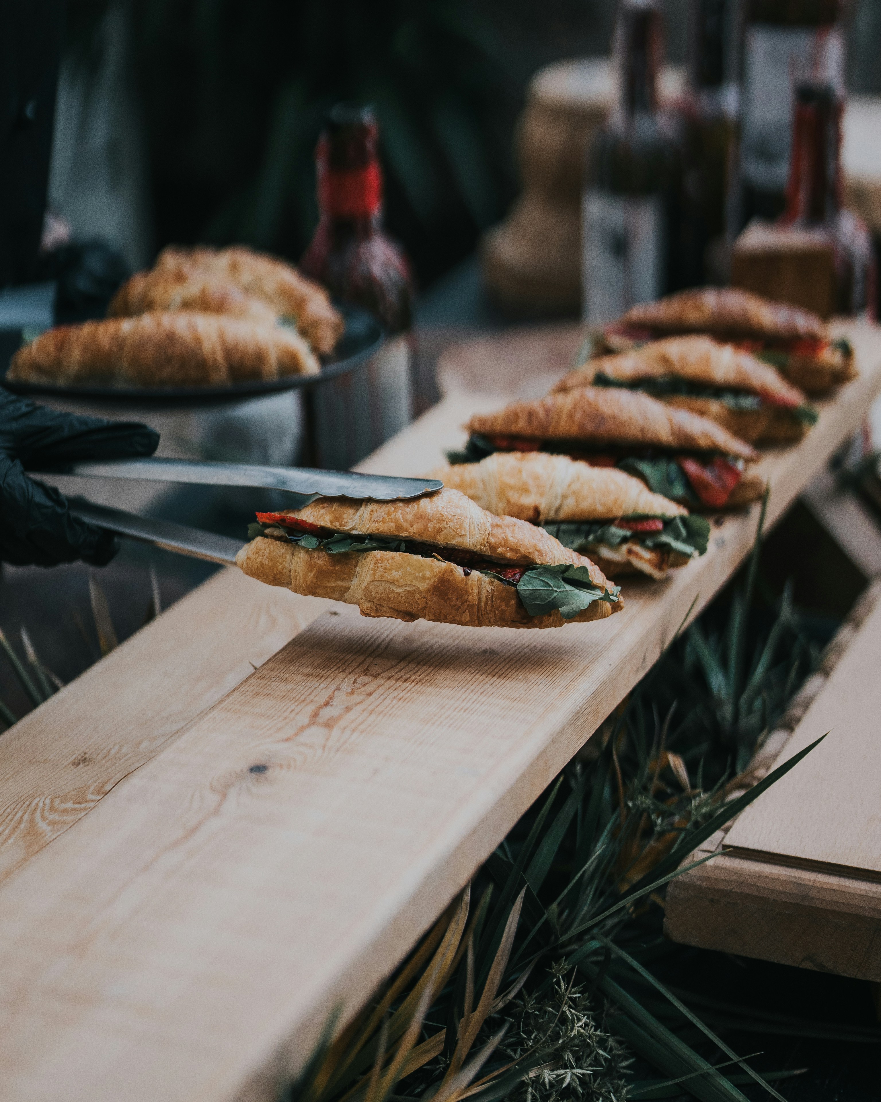 A wooden table topped with lots of sandwiches