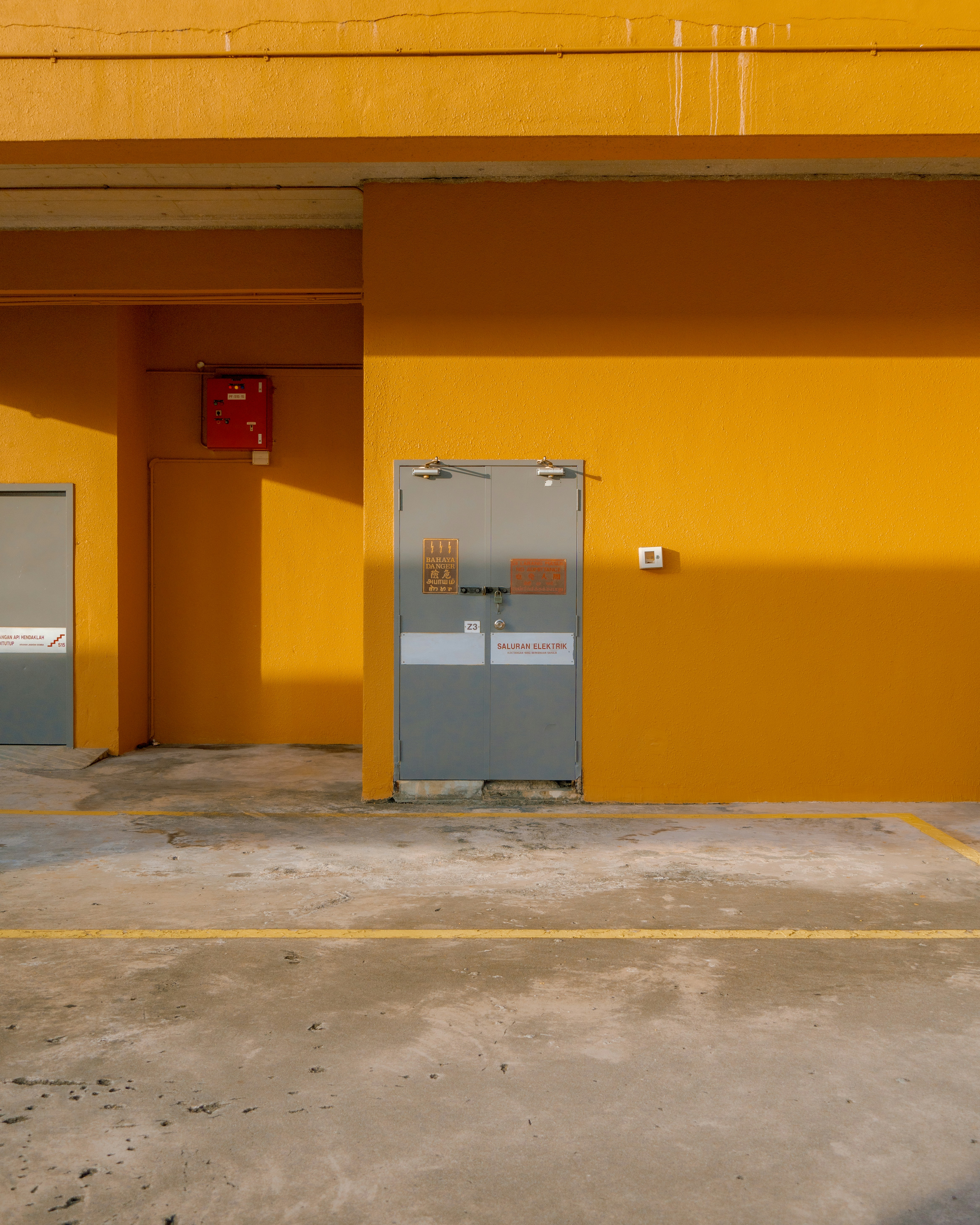 An empty parking lot with a yellow building in the background