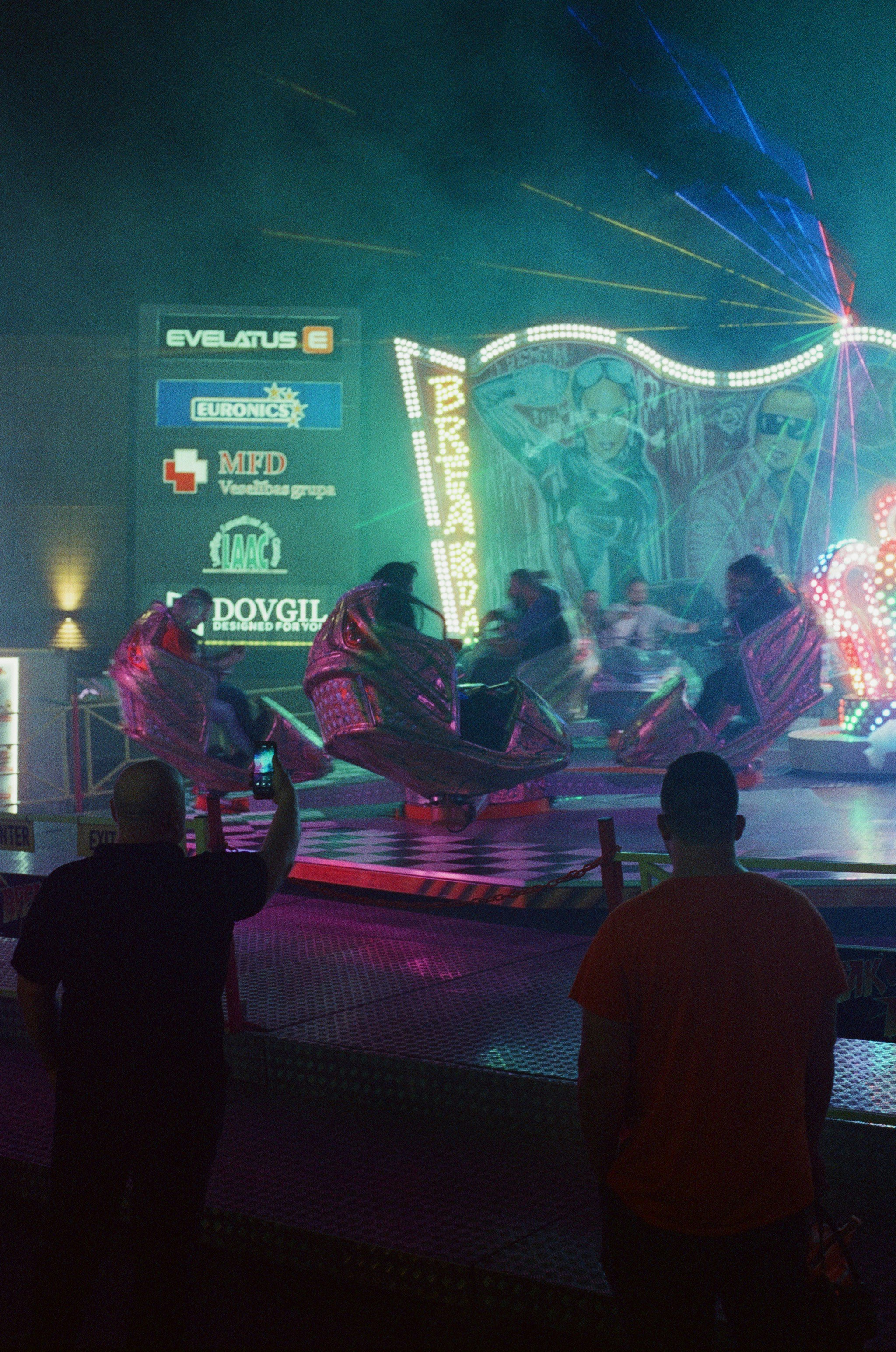 A group of people standing around a carnival ride
