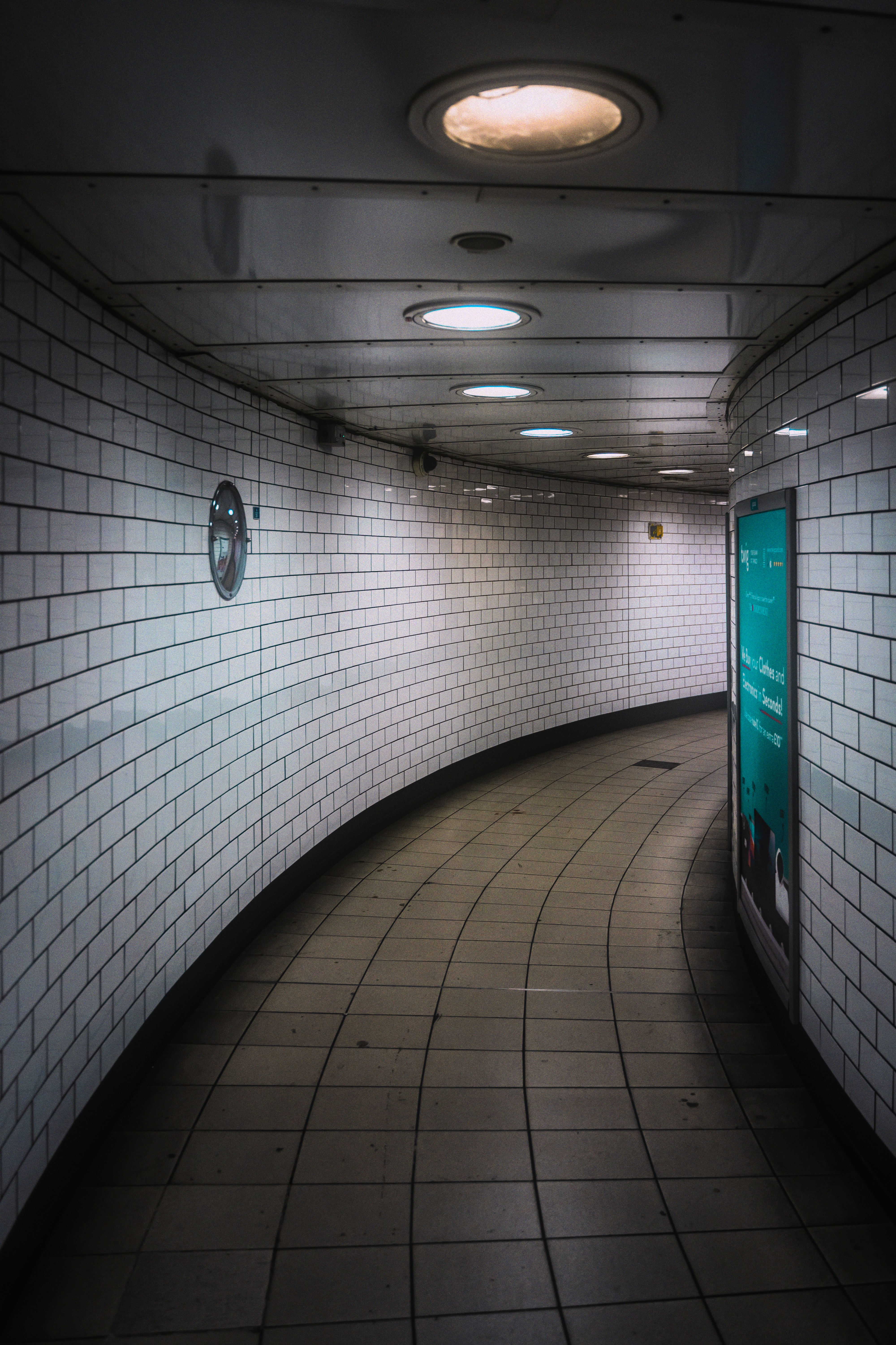 An empty subway tunnel with a clock on the wall