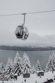 A ski lift with a ski lift going up a snowy mountain