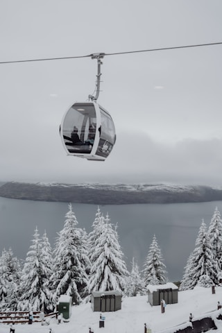 A ski lift with a ski lift going up a snowy mountain