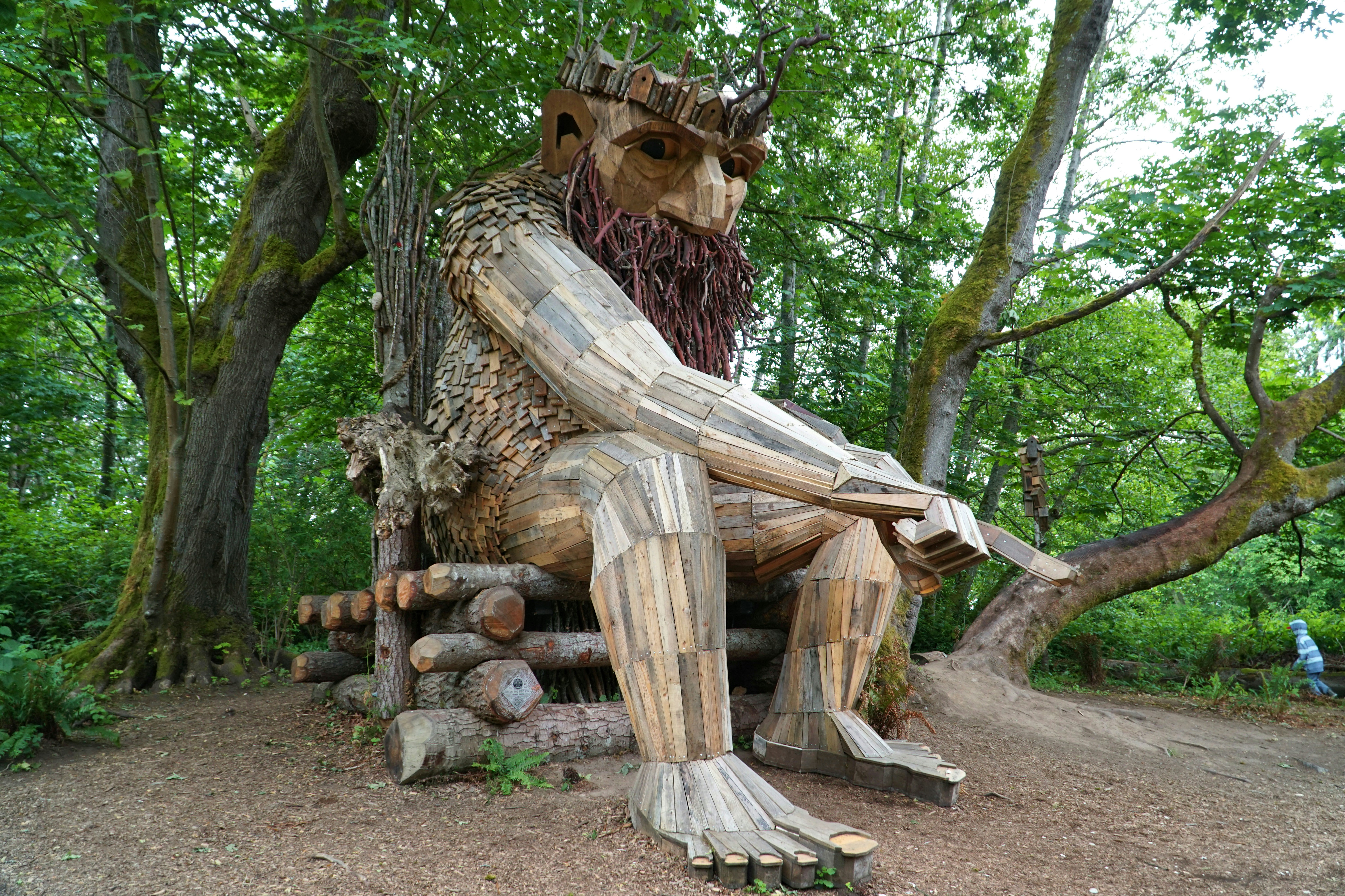 Uma estátua de um homem sentado em cima de um toco de árvore