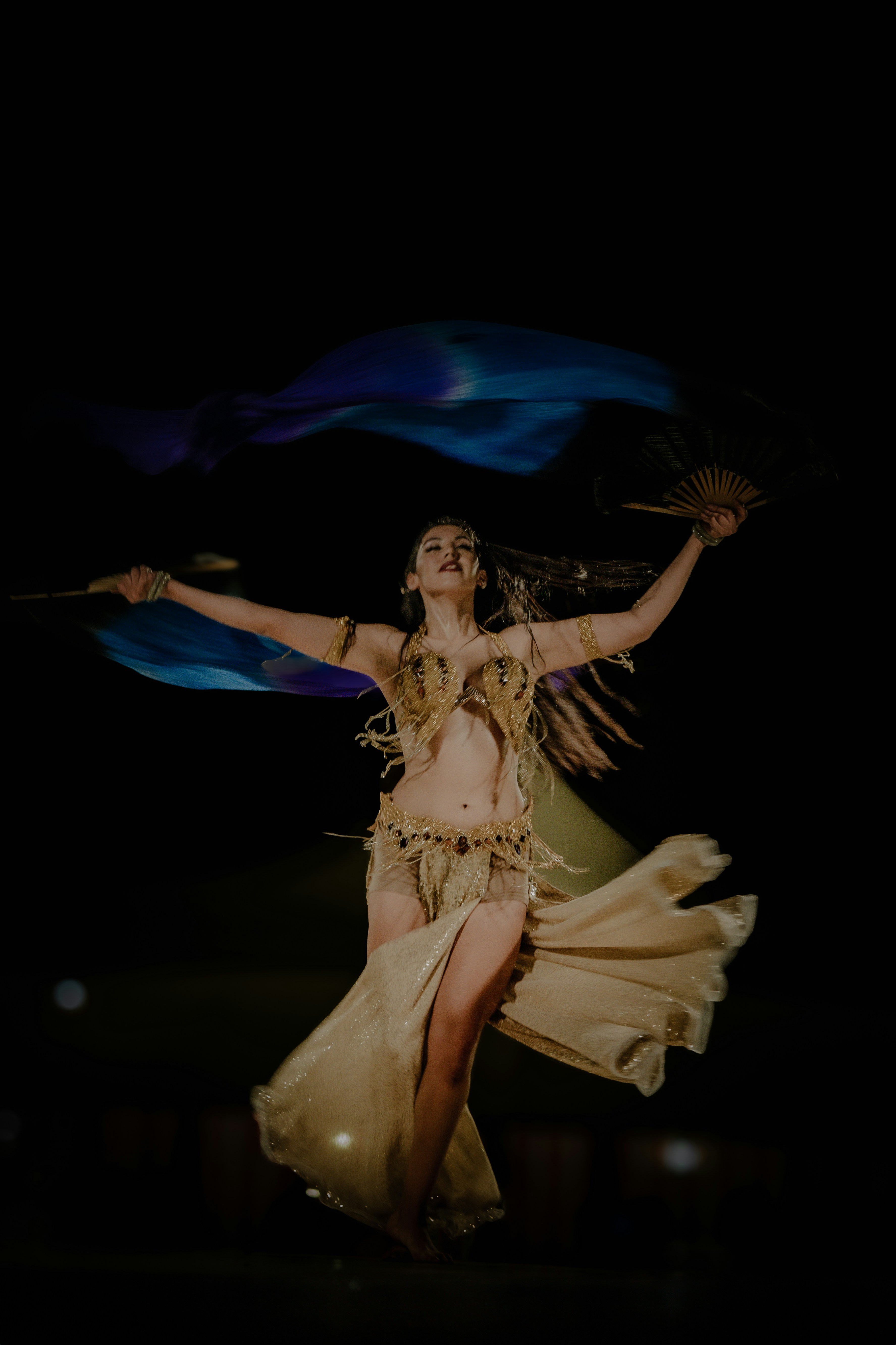 A woman in a belly dance costume is dancing