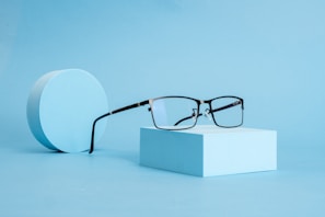 A pair of glasses sitting on top of a white box
