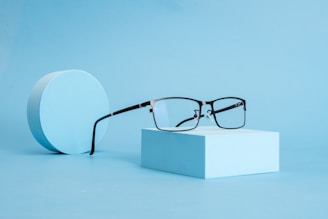A pair of glasses sitting on top of a white box