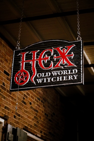 A sign hanging from the side of a brick building