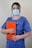A woman wearing a surgical mask holding a clipboard