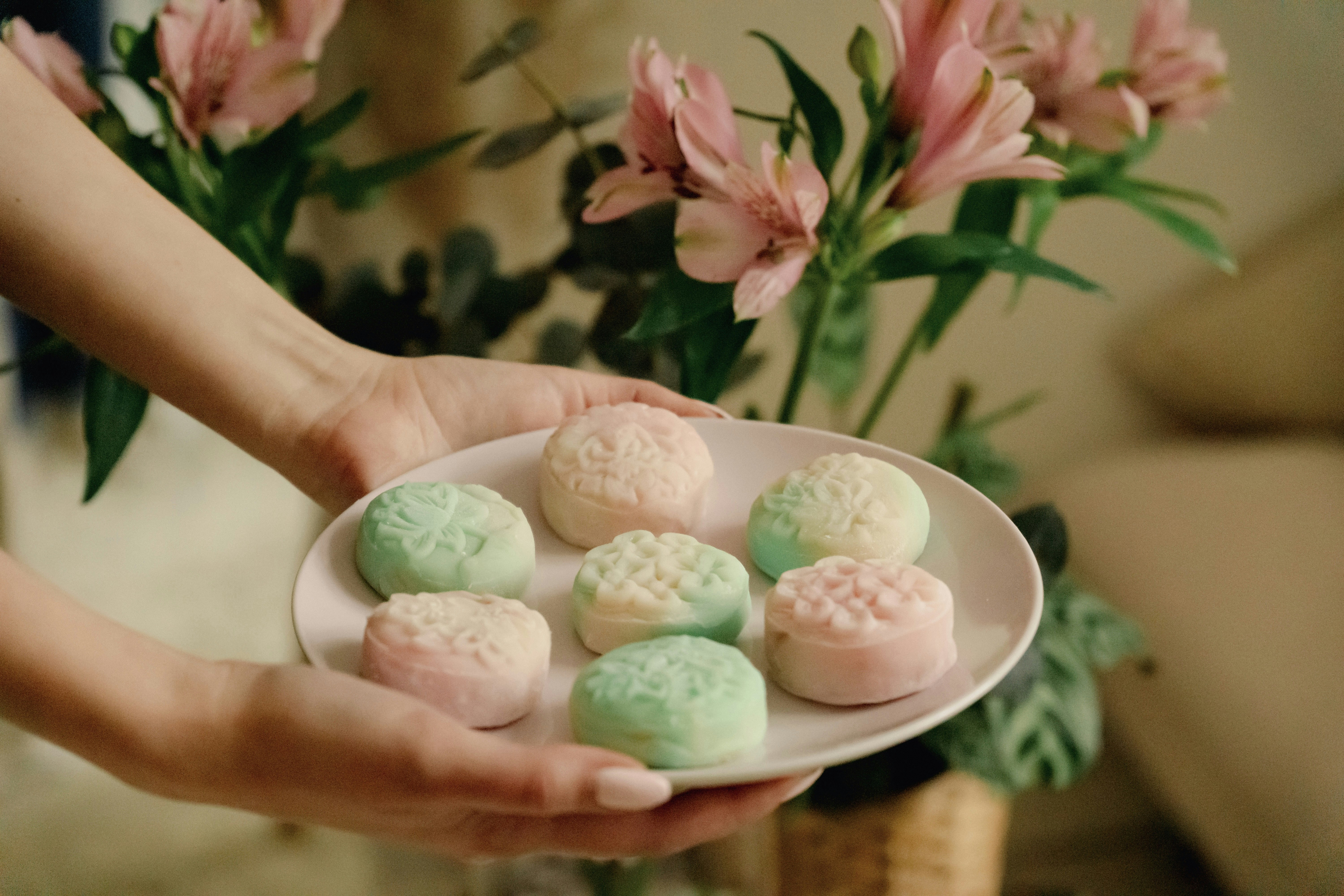 Une personne tenant une assiette de biscuits sur une table