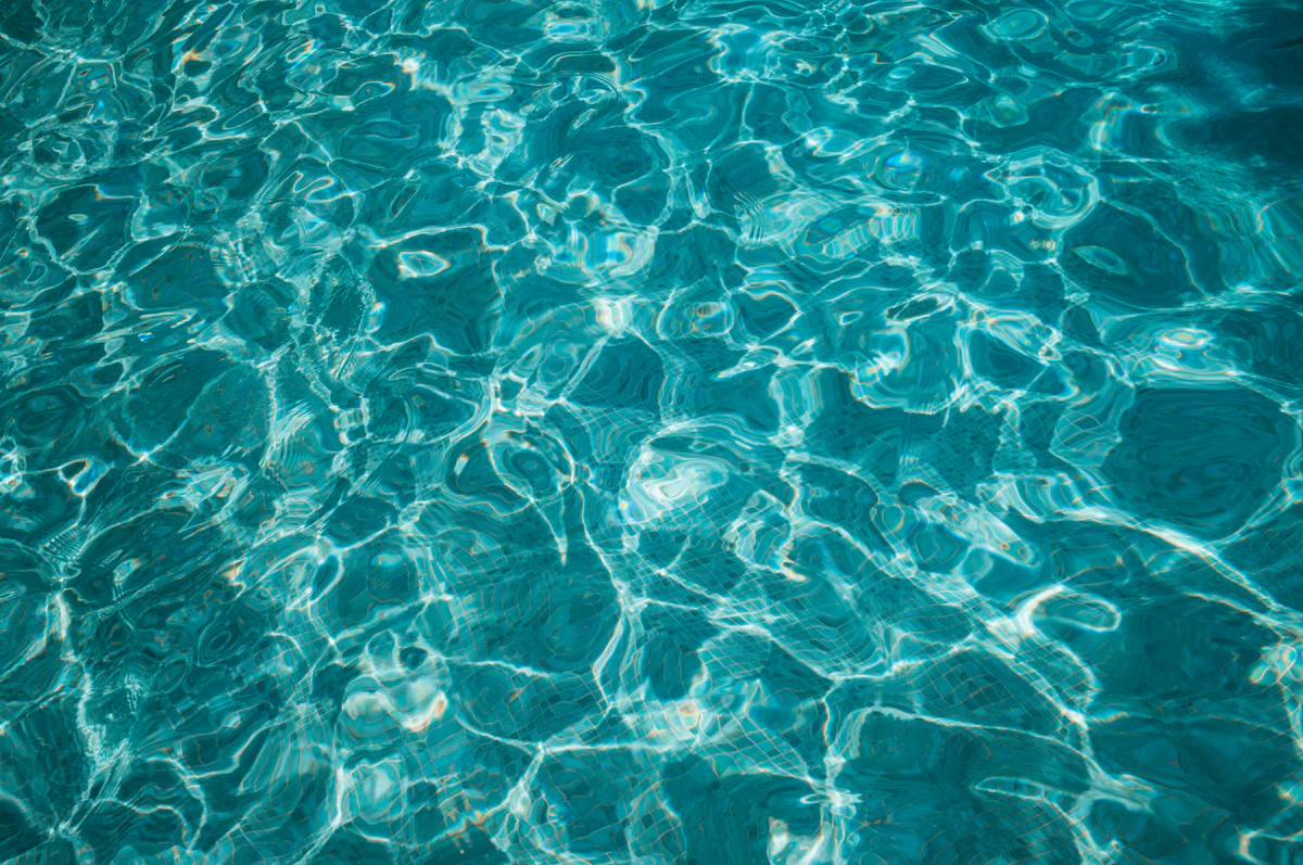 Overhead view of a clean, well-maintained swimming pool with sparkling blue water on a sunny day