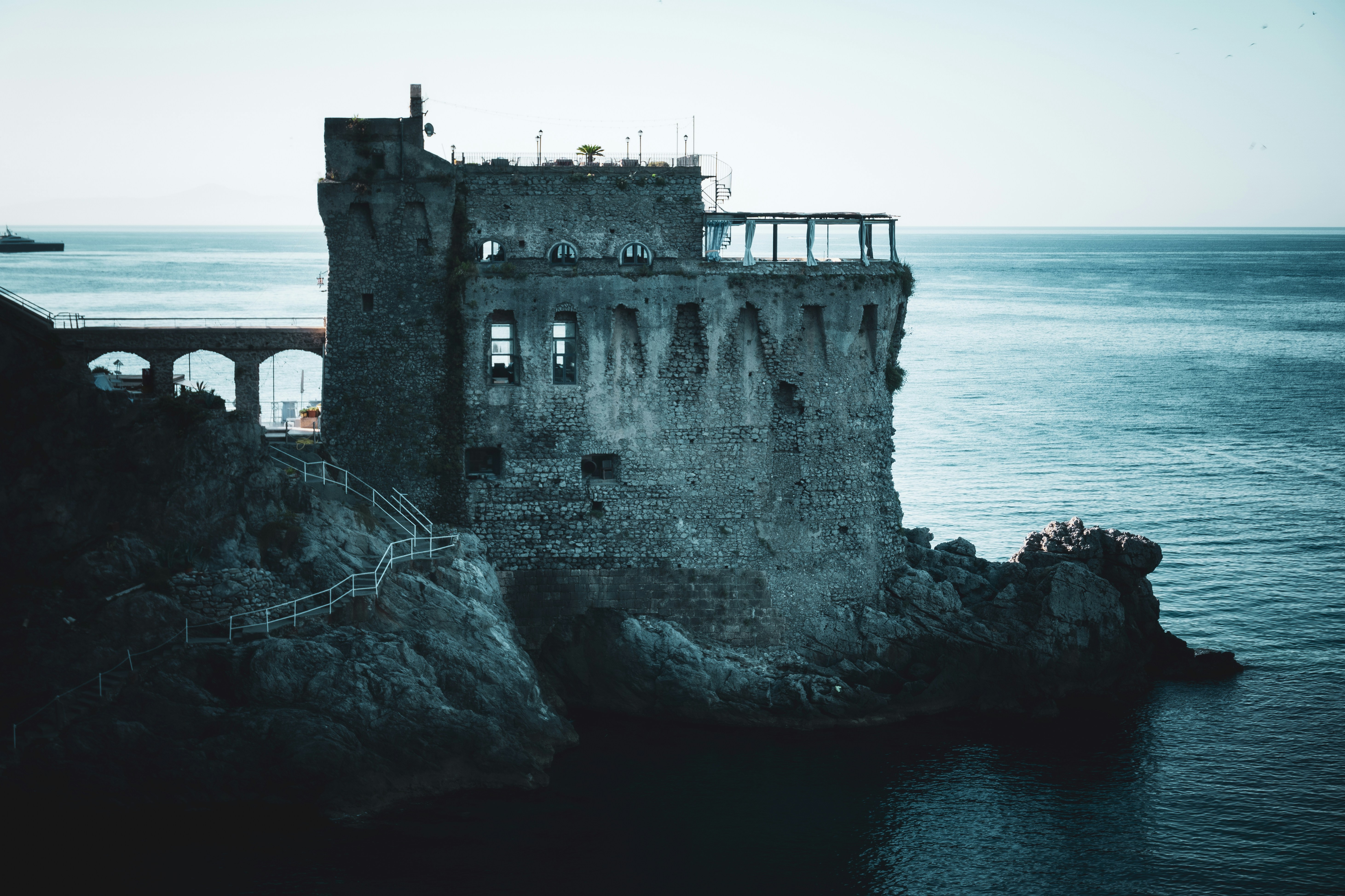 An old building sitting on top of a cliff next to the ocean