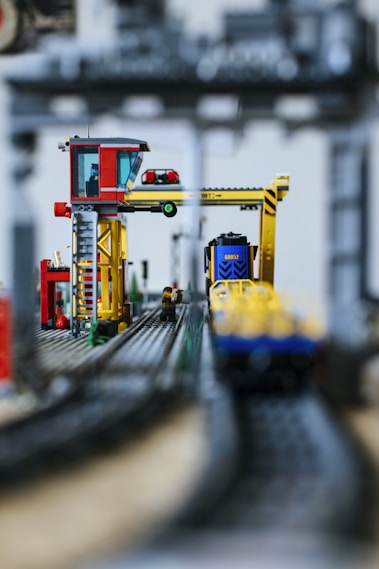 A toy train on a track with a crane in the background