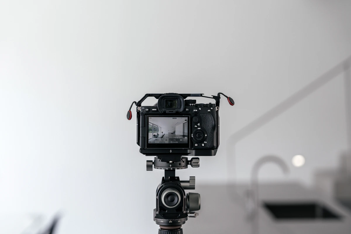 A photographer's camera and tripod set up in a sunlit interior