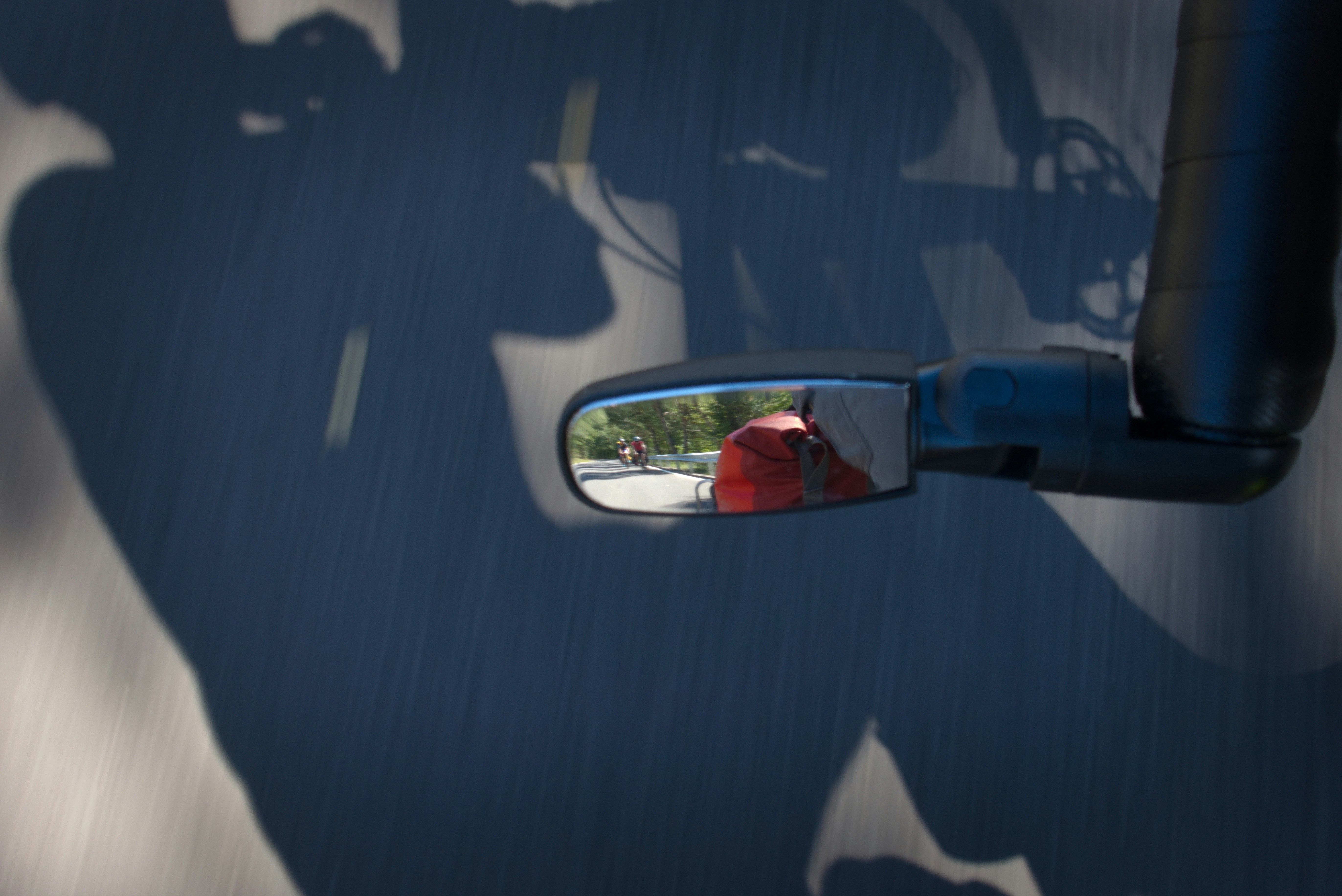 A side view mirror reflecting a person on a motorcycle