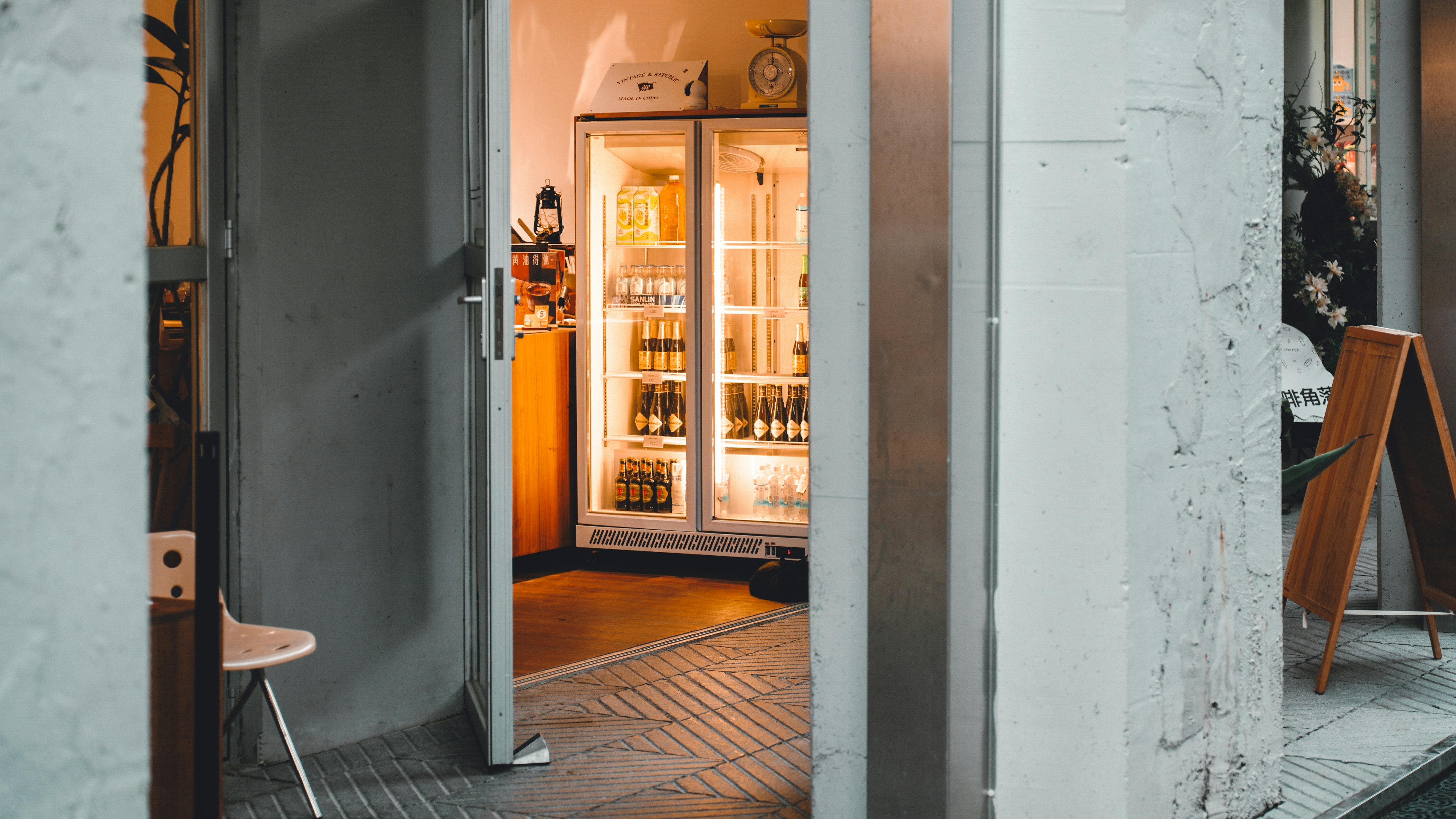 An open door leading into a room with a refrigerator
