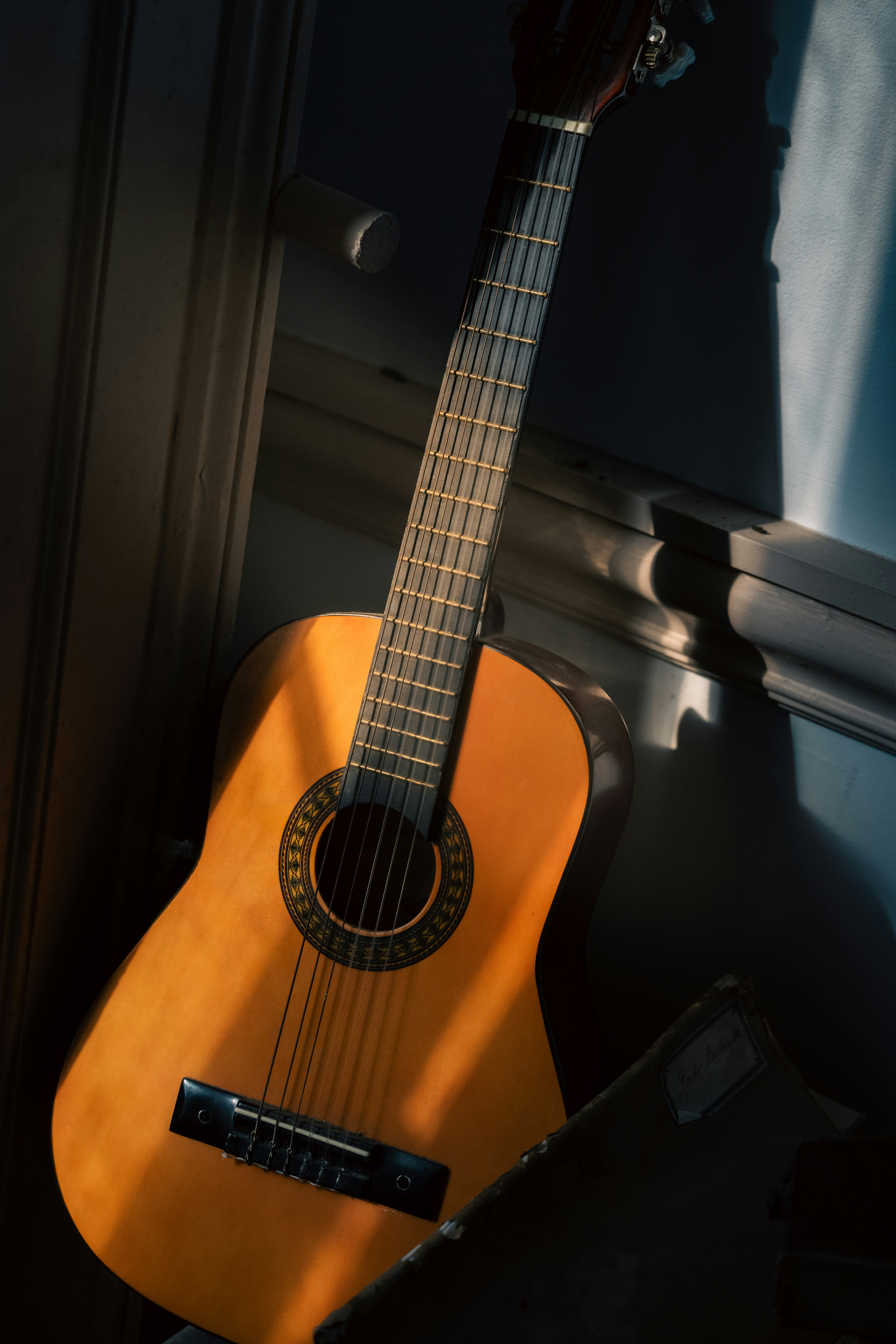 A guitar sitting next to a window in a room