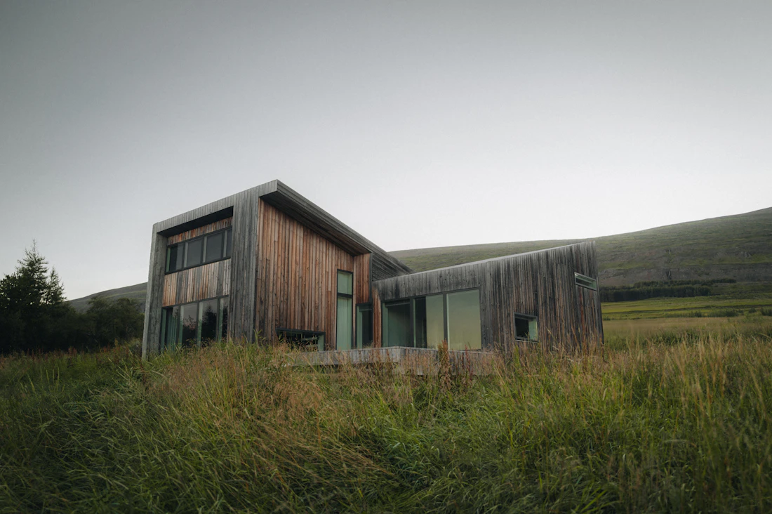A weathered timber house standing in tall grass