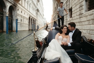 A man and a woman riding a gondola down a street