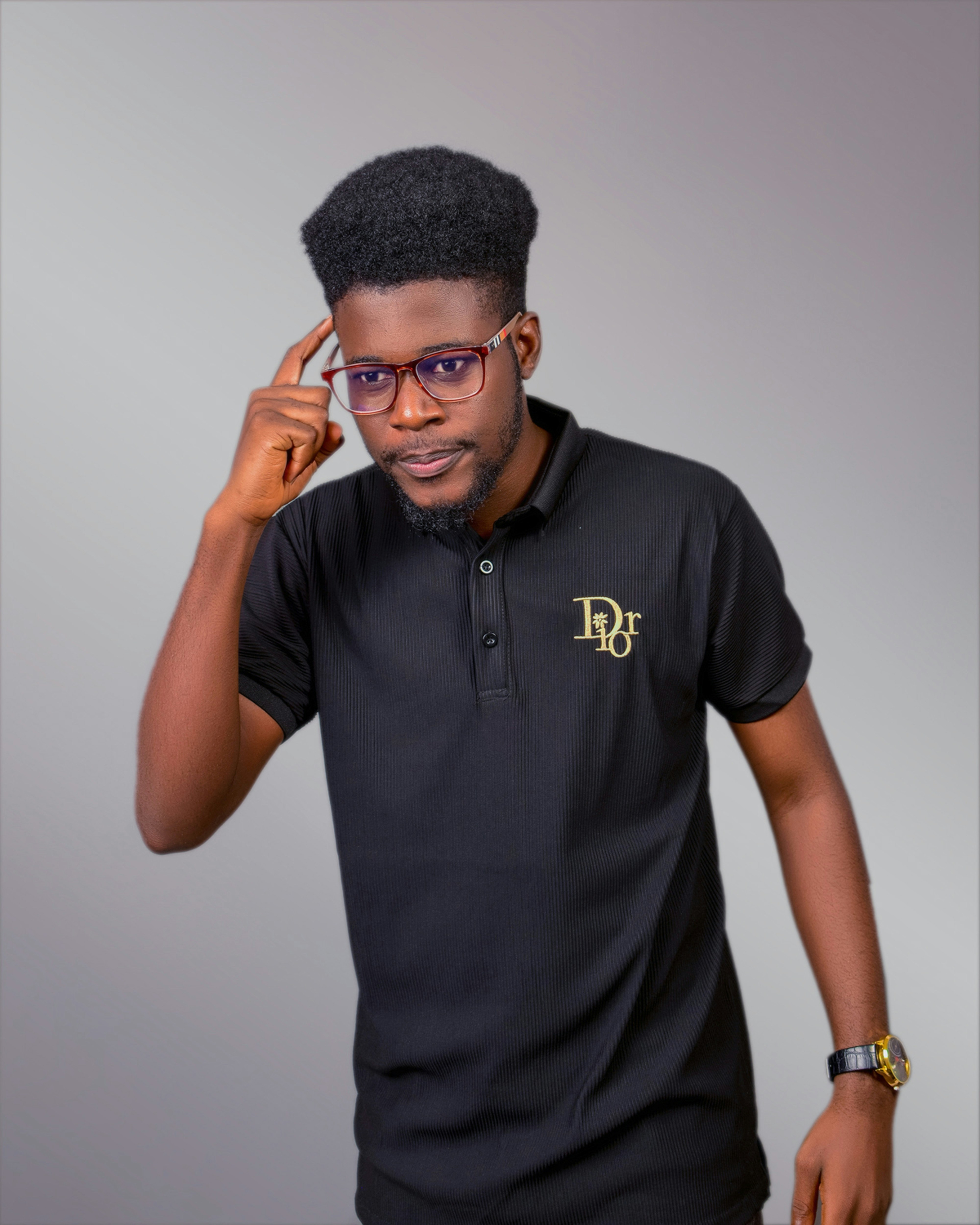 A man in a black polo shirt is talking on a cell phone