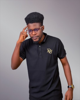 A man in a black polo shirt is talking on a cell phone