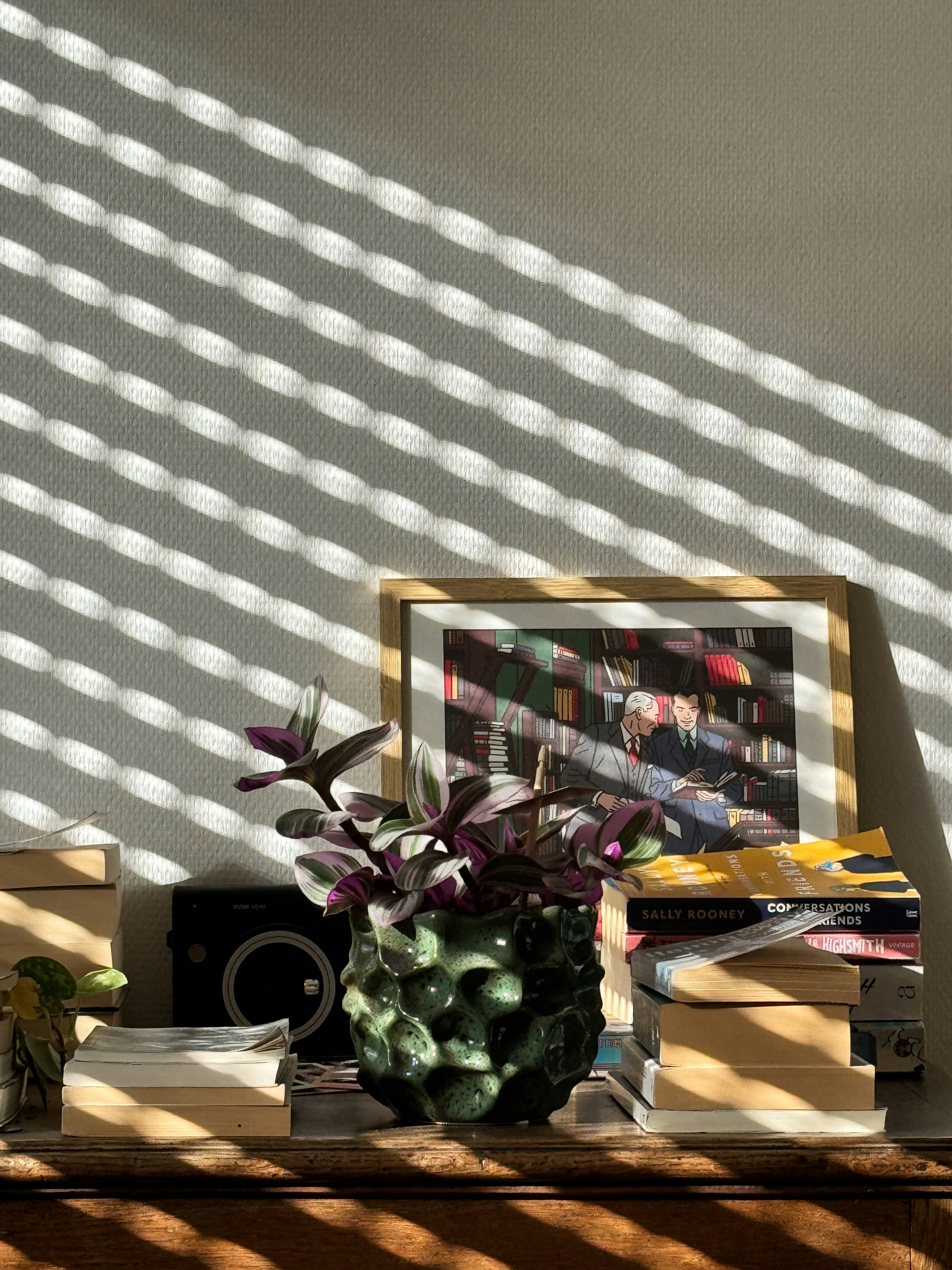 Une table avec un vase de fleurs et des livres dessus