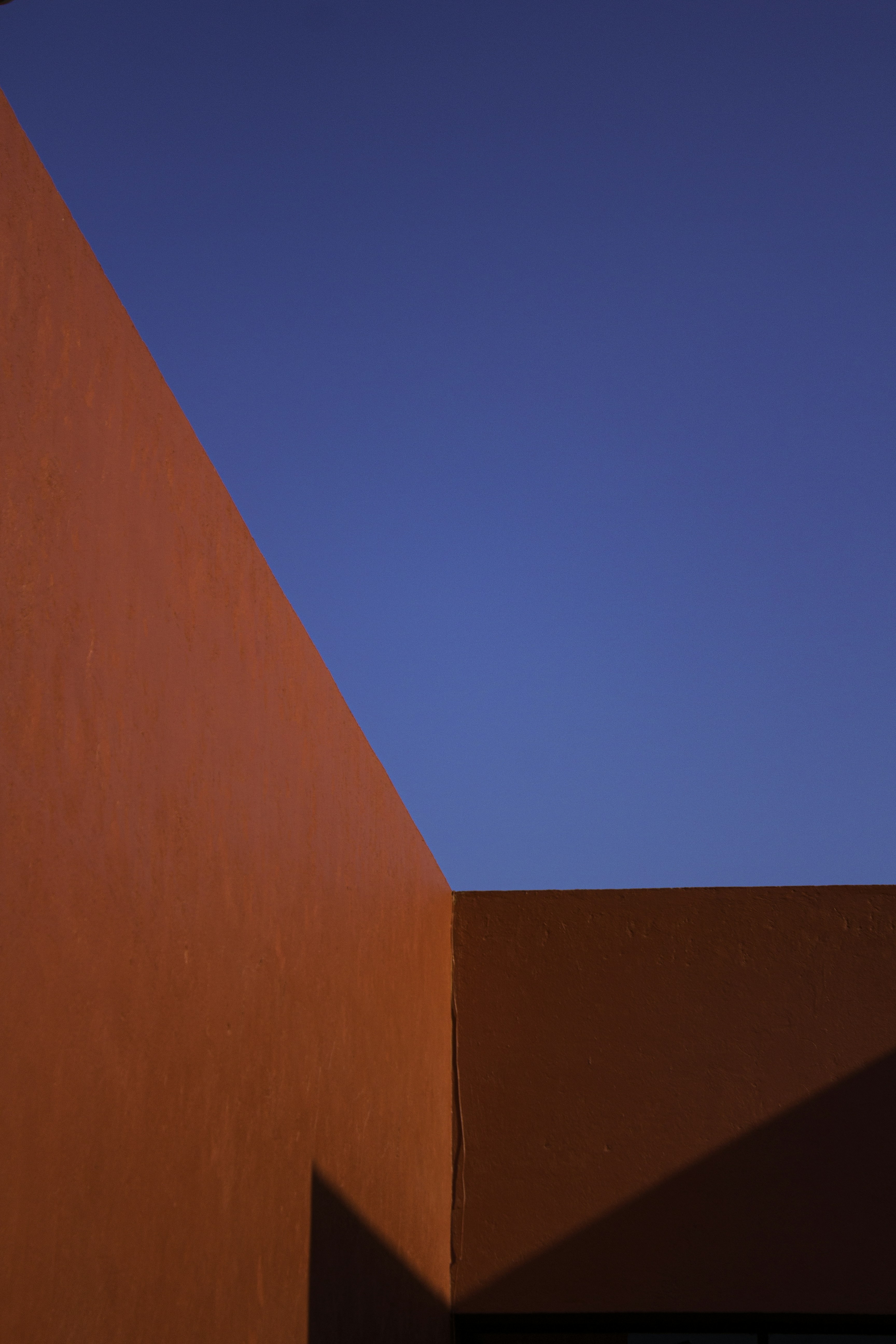 A man riding a skateboard up the side of a red wall
