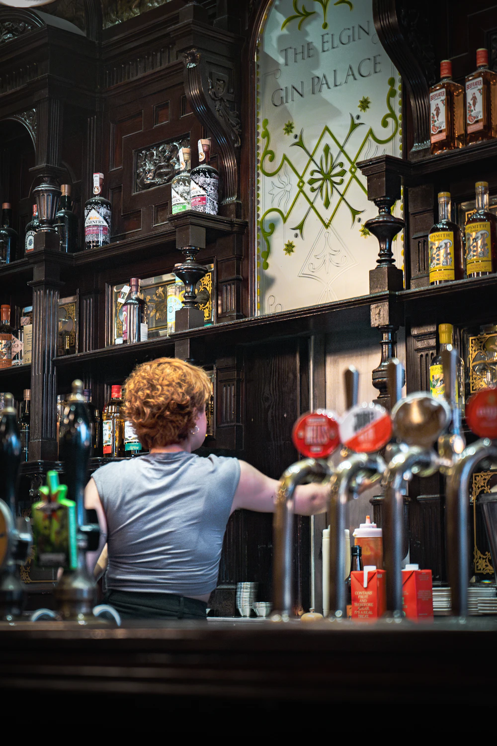 Bartender serving drinks behind a traditional bar