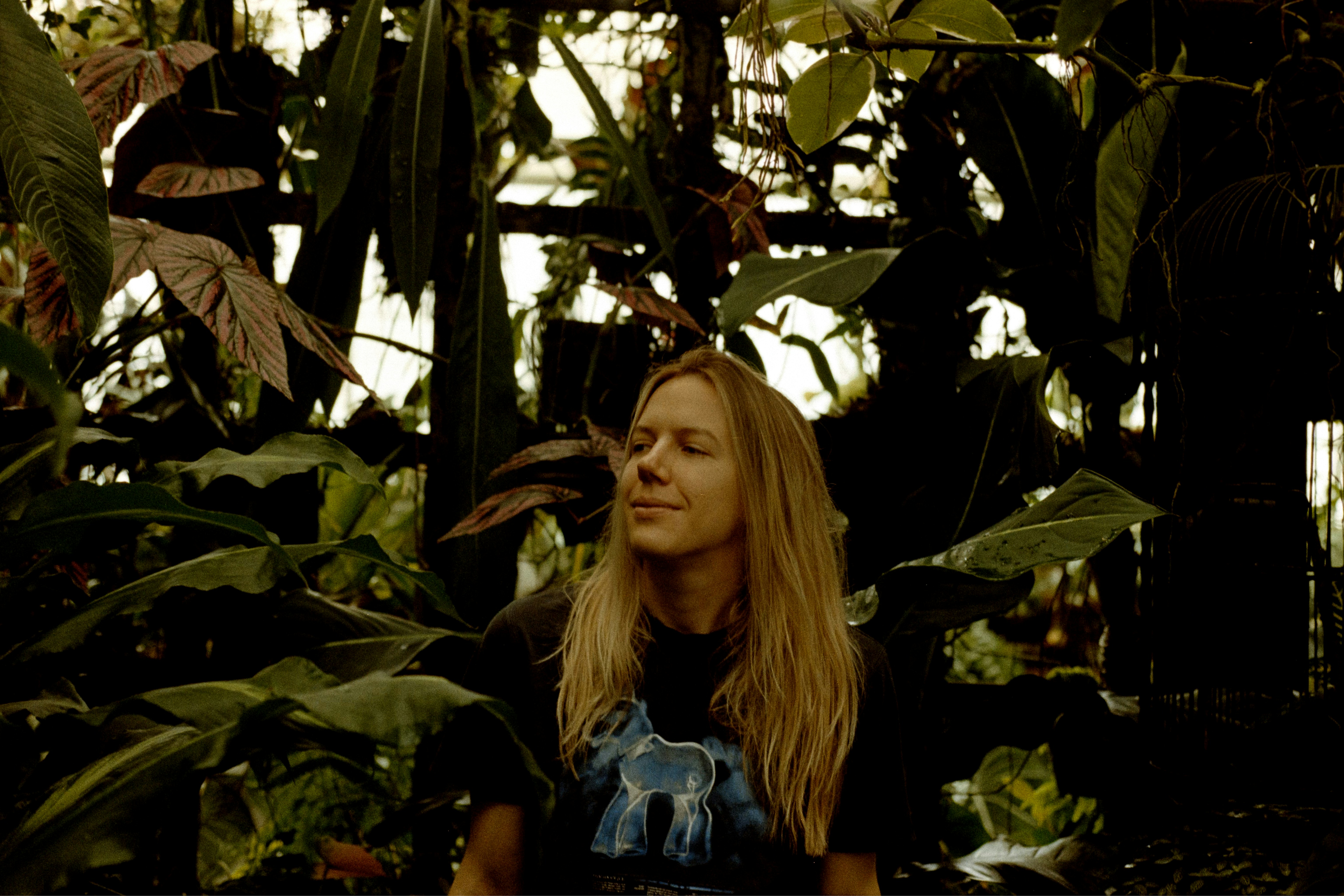 A woman standing in front of a bunch of plants