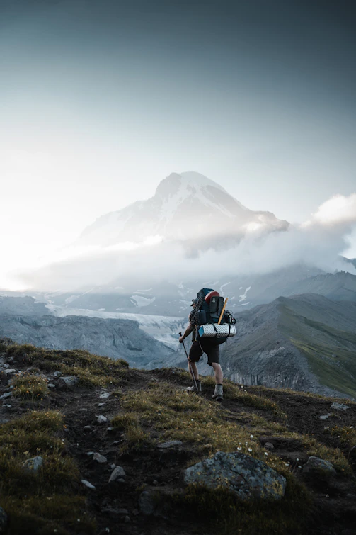 A man hiking up a mountain with a backpack