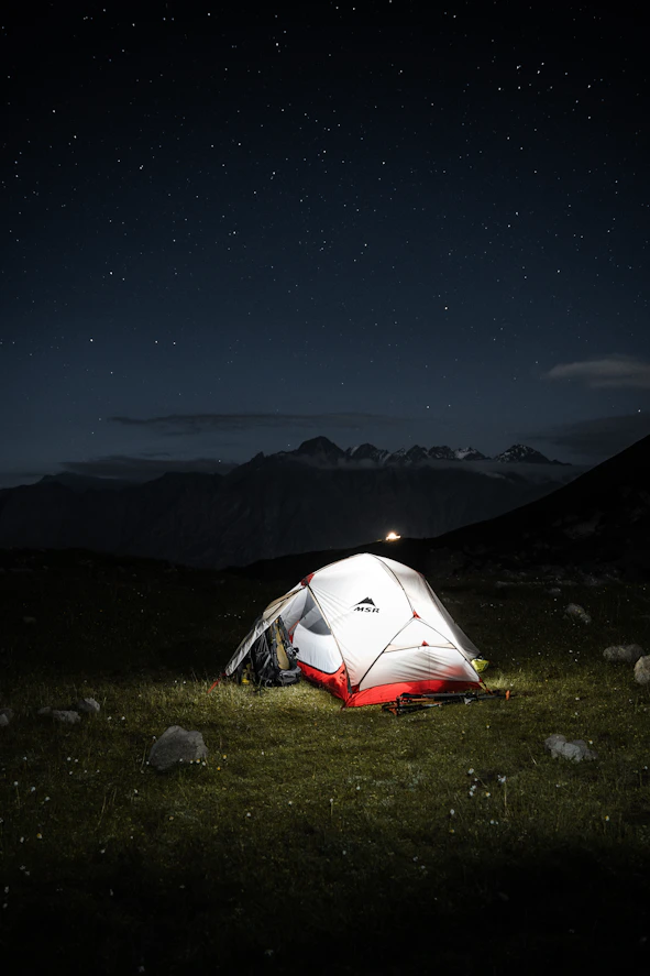 A tent pitched up in a field at night
