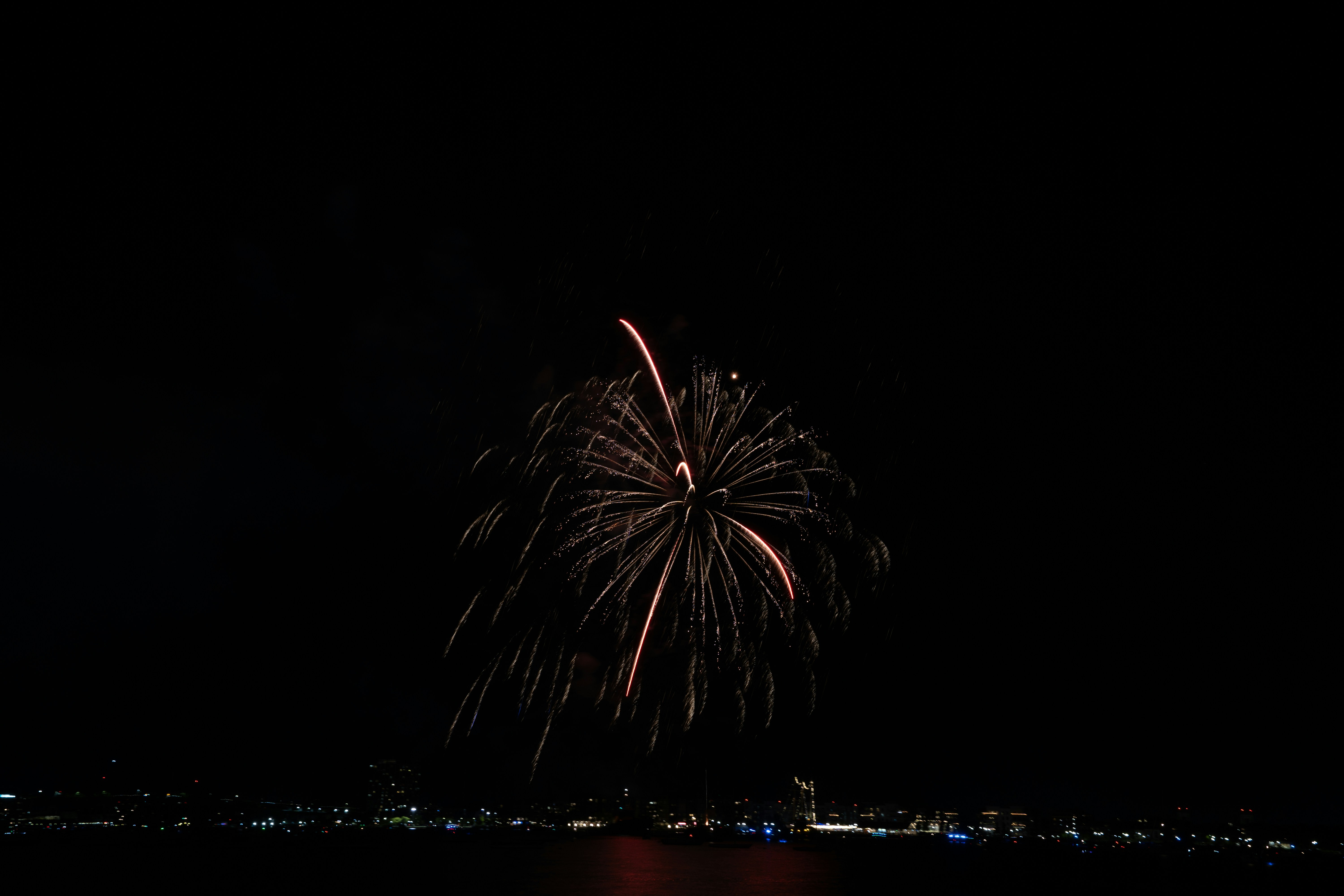 A large fireworks is lit up in the night sky