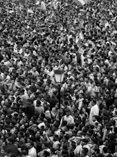 A large crowd of people standing around each other