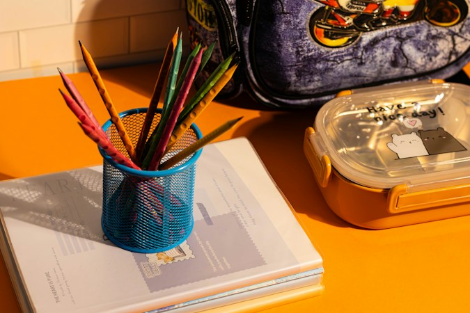 A blue child's school backpack resting on a yellow table, the kind of everyday backpack elementary students carry to class in Las Vegas