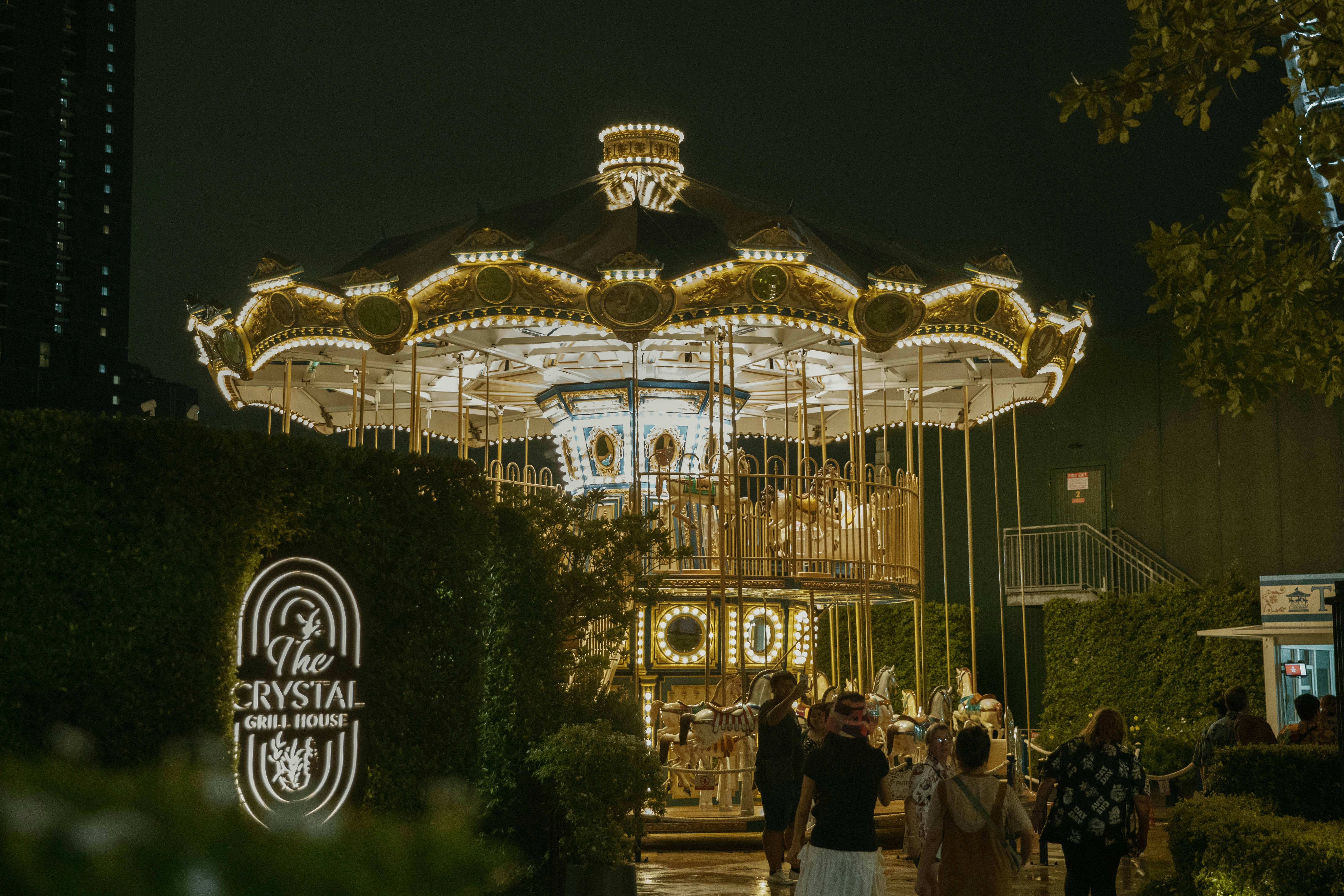 A group of people standing around a merry go round