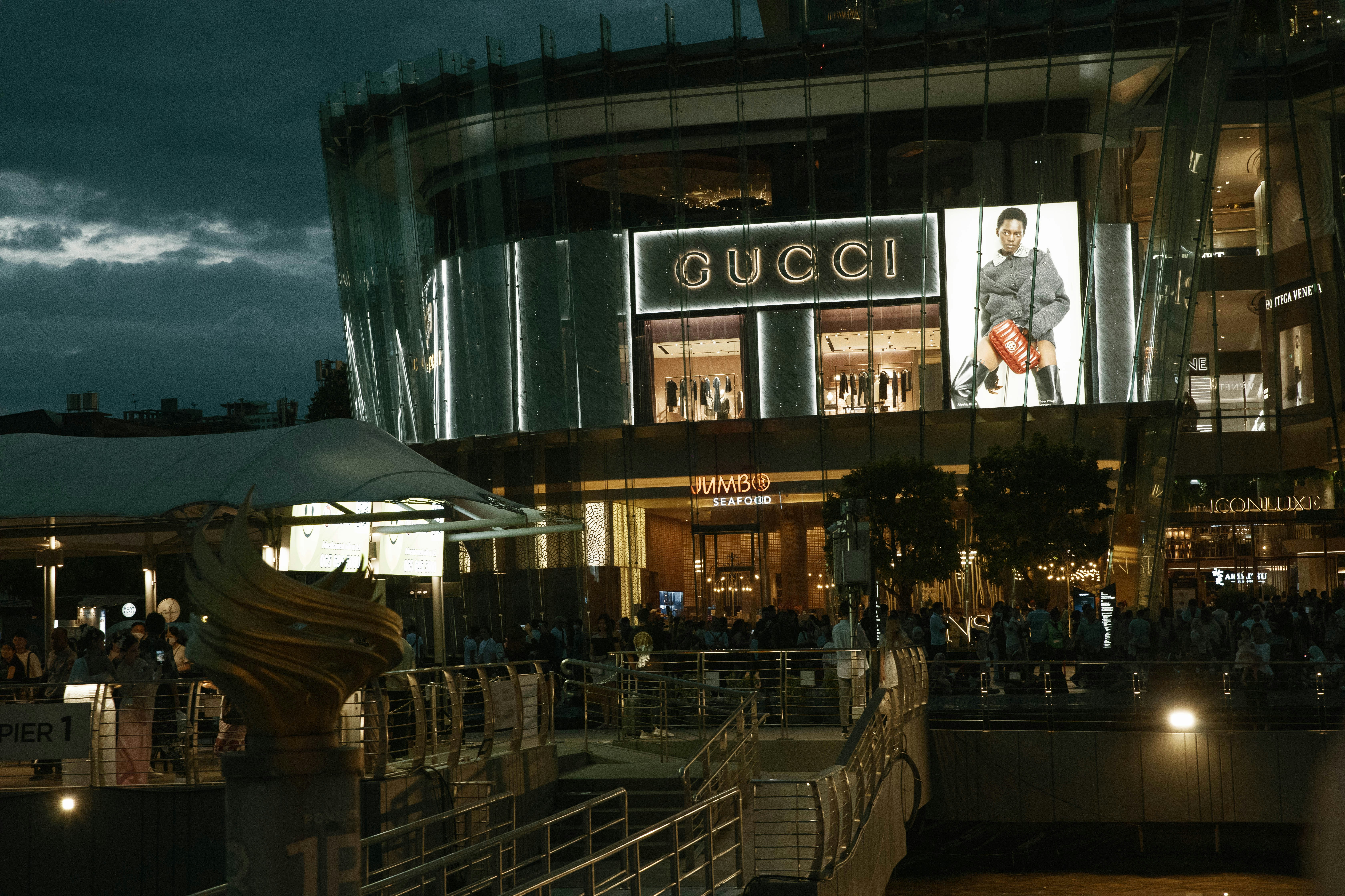 A crowd of people standing outside of a building at night