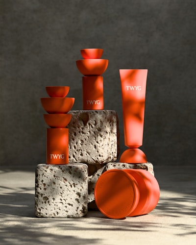 A group of orange vases sitting next to each other