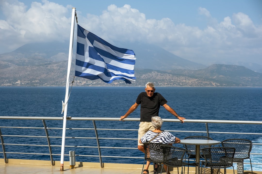 A man standing on a balcony next to a flag,