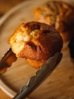 A close up of a muffin on a plate with a fork