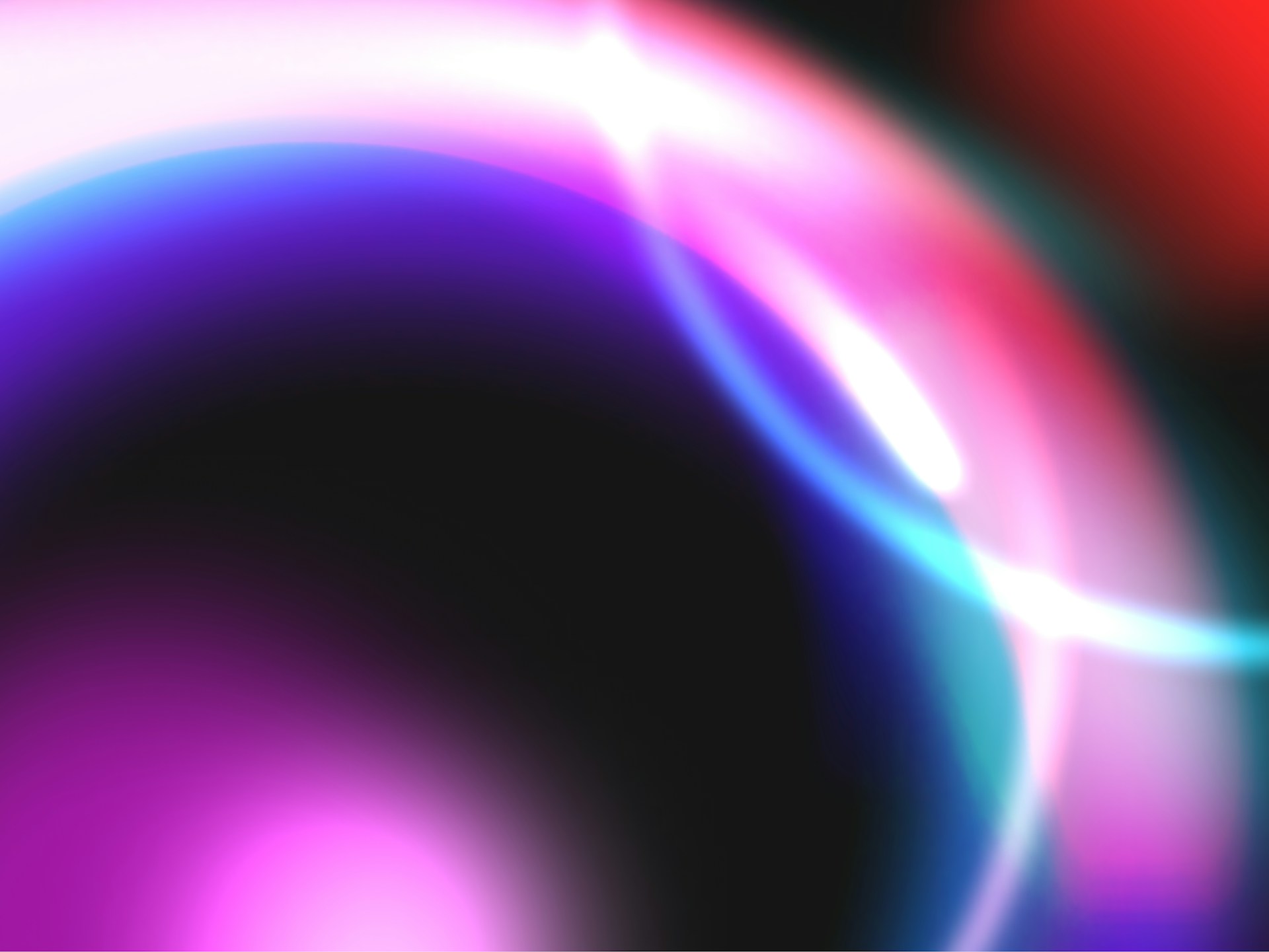 A blurry image of a red, pink, and blue circle