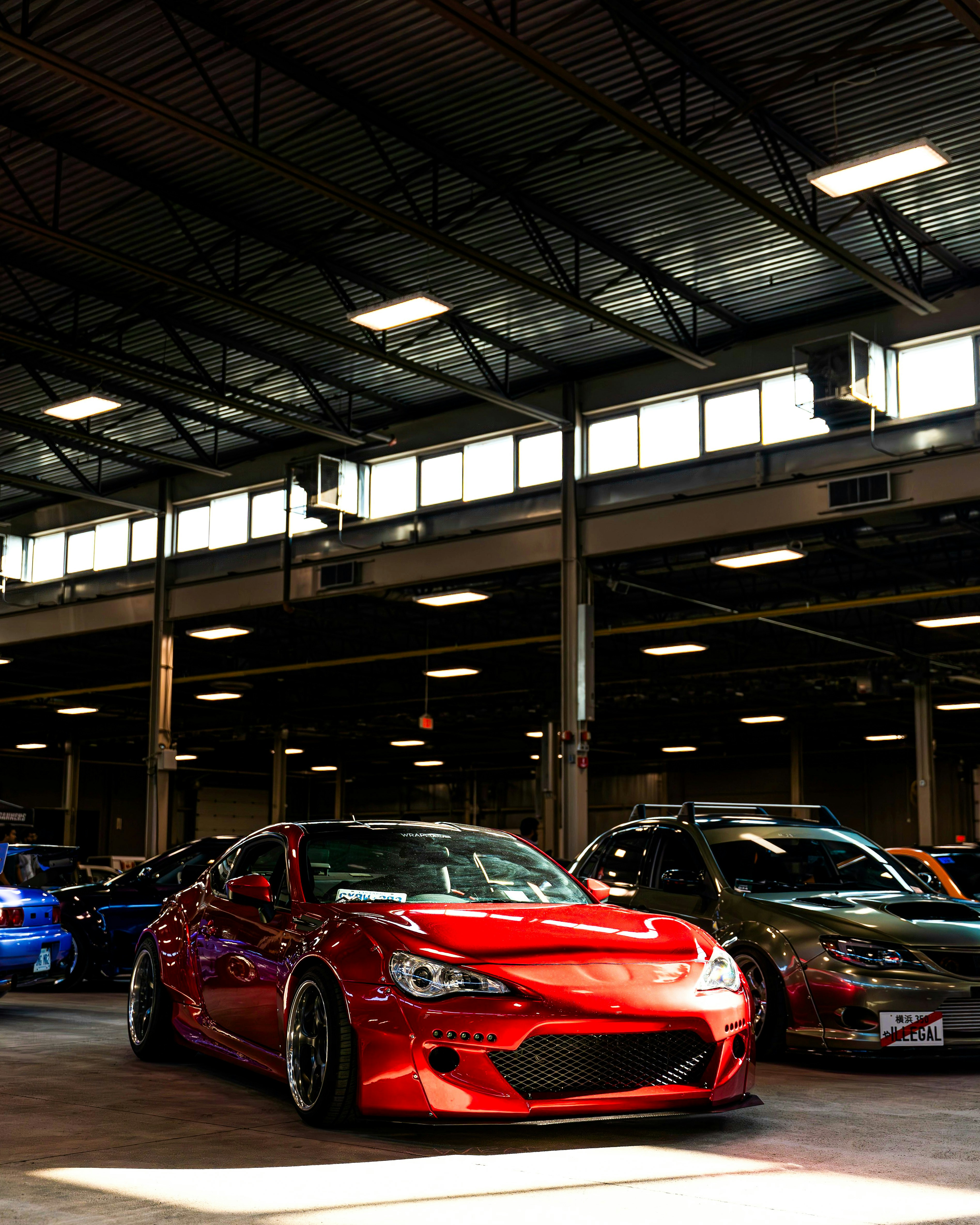 A group of cars parked inside of a garage