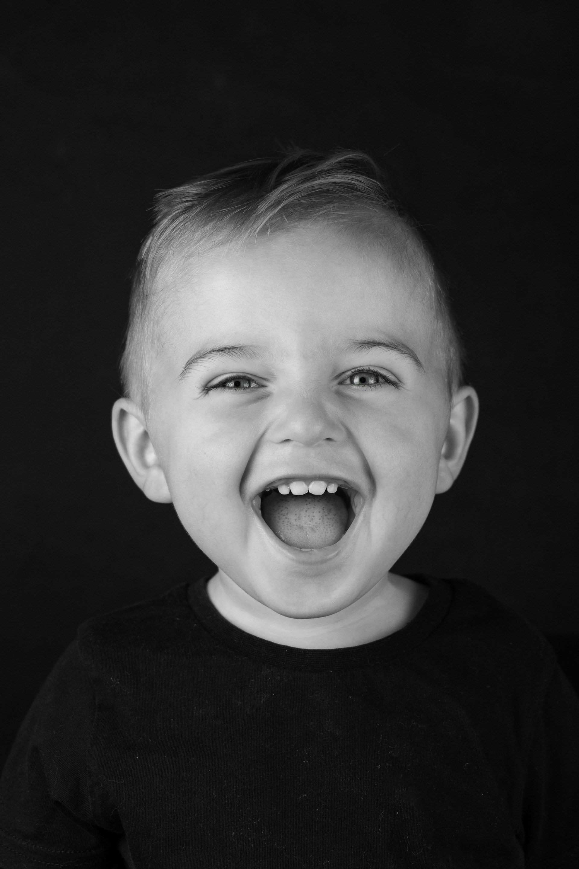 A young boy making a funny face with his mouth open